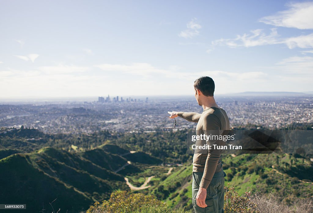 Man standing on top of hill looking at horizon