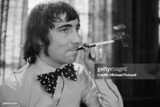 Drummer Keith Moon of English rock group The Who, wearing a large bow tie and using a cigarette holder, 24th April 1973.