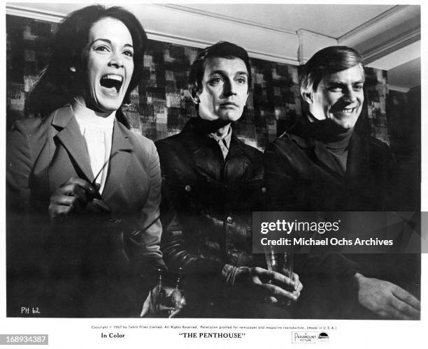 Norman Rodway, Martine Beswick and Tony Beckley sitting side by side in a scene from the film 'The Penthouse', 1967.