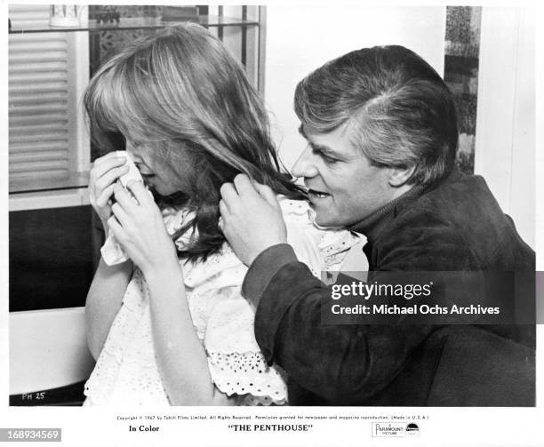 Suzy Kendall cries as Norman Rodway tries to comfort her in a scene from the film 'The Penthouse', 1967.