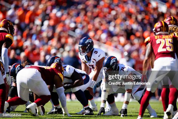 Quarterback Russell Wilson of the Denver Broncos lines up under center during the second quarter against the Washington Commanders at Empower Field...