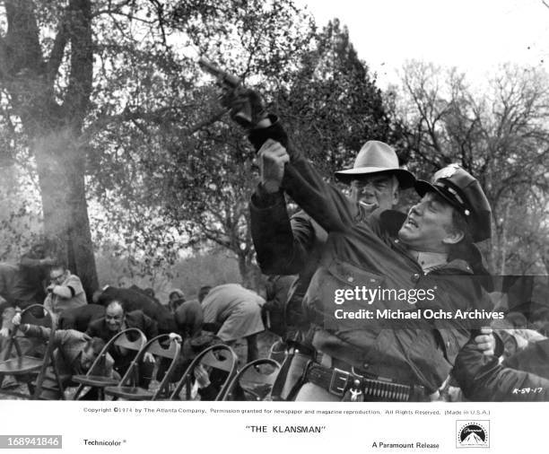 Lee Marvin tries to stop Cameron Mitchell from shooting a gun in a scene from the film 'Klansman', 1974.