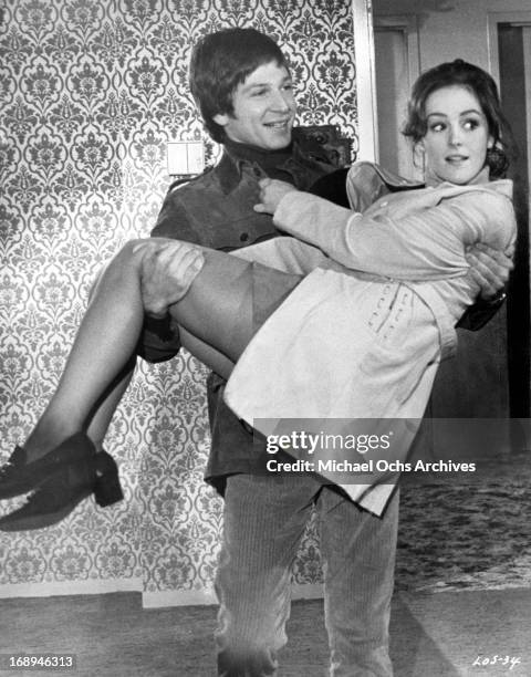 Michael Brandon carries Bonnie Bedelia in a scene from the film 'Lovers And Other Strangers', 1970.