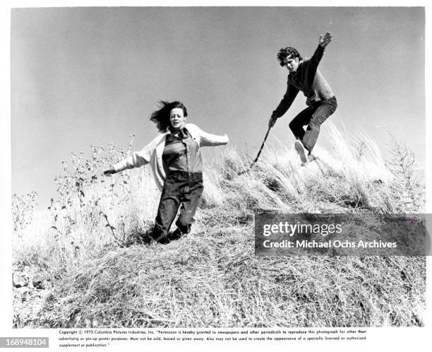 Maggie Smith and Timothy Bottoms fall down a hill in a scene from the film 'Love And Pain And The Whole Damn Thing', 1973.