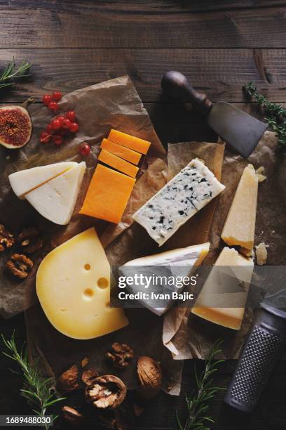 verschiedene käsesorten auf rustikalem hintergrund - blauschimmelkäse stock-fotos und bilder
