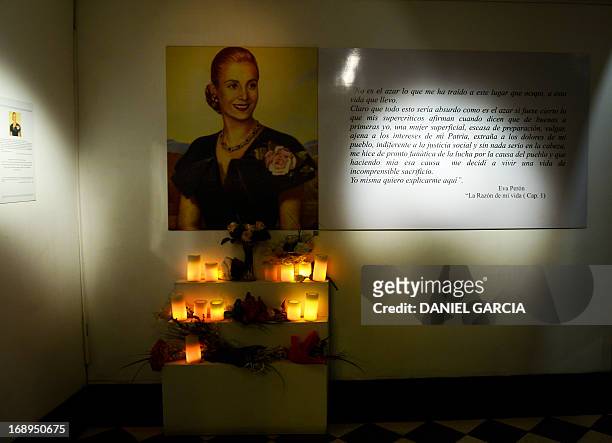 View of a portrait of Eva Duarte de Peron, "Evita" with lit cadles displayed at the main hall of the Evita Museum in Buenos Aires on May 16, 2013....