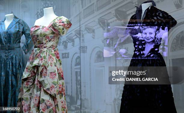 The image of the projection of a documentary film about Eva Duarte de Peron, "Evita" is reflected on a glass cabinet with dresses who belonged to...