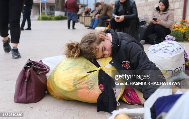 Girl sleeps in a street in the town of Stepanakert on September 25, 2023. Ethnic Armenian refugees began to leave Nagorno-Karabakh on September 24,...