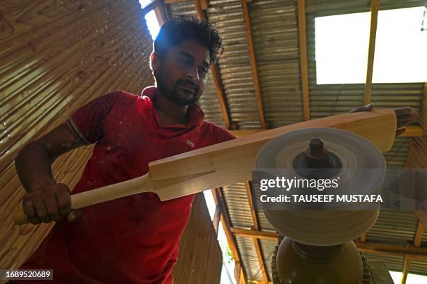 In this picture taken on August 19 a worker crafts a Kashmiri willow wood cricket bat at a factory in Kashmir's Sangam village. When the cricket...