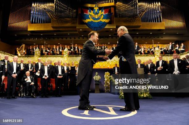 Professor Adam Riess of the US receives the Nobel Prize in Physics from King Carl XVI Gustaf of Sweden during the Nobel prize award ceremony at the...