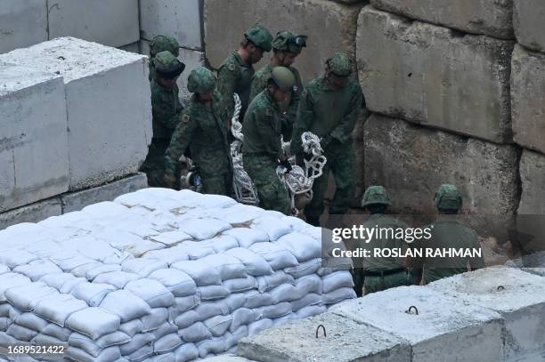 Singapore Armed Forces specialists carry a 100kg World War II-era aerial bomb as they prepare for a disposal operation at a construction site in...