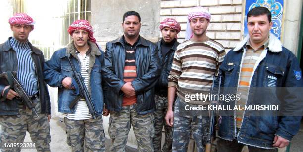 Saddam Hussein , a member of the self proclaimed 'Army of National Liberation' poses with his comrades at a street in Baghdad's central Fadel area,...