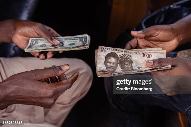 Customer exchanges Nigerian 1000 Naira banknotes for US dollar banknotes with a street currency dealer at a market in Lagos, Nigeria, on Monday,...