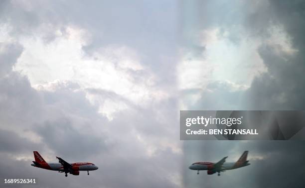 An EasyJet Airbus 319-111 aircraft is reflected in a window as it prepares to land at London Gatwick Airport, near Crawley, southern England, on...