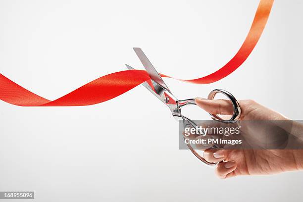 hand cutting red ribbon with scissors - inaugurazione foto e immagini stock