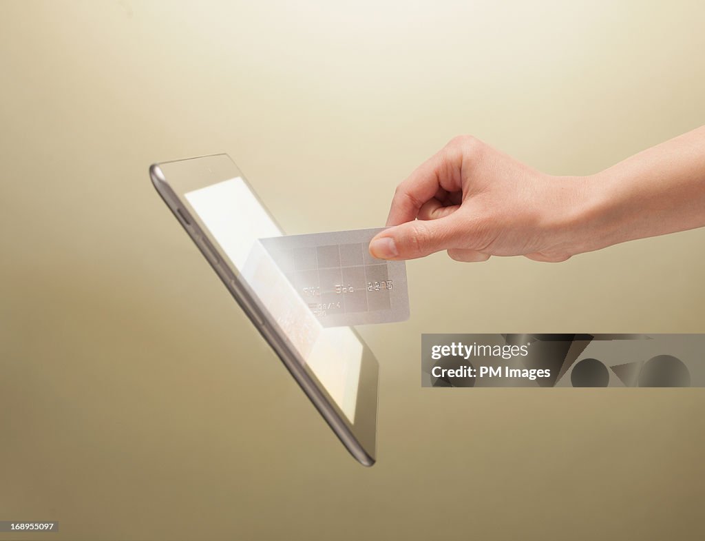 Hand placing credit card into tablet