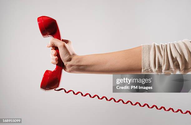 woman's hand holding red phone - telephone receiver fotografías e imágenes de stock