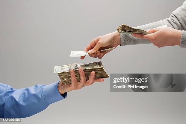 woman handing man money - geben stock-fotos und bilder