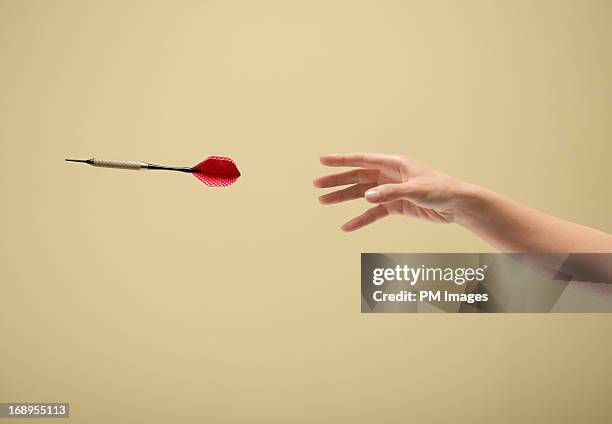 hand throwing dart - throwing fotografías e imágenes de stock