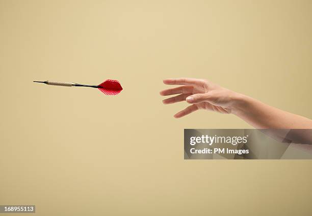 hand throwing dart - lance photos et images de collection