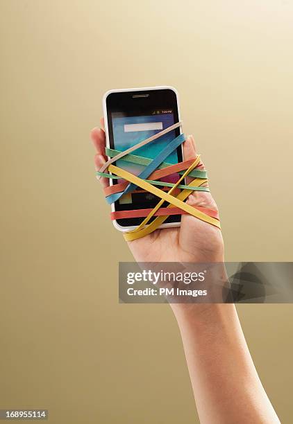 smart phone atached to hand - phone addiction stock pictures, royalty-free photos & images