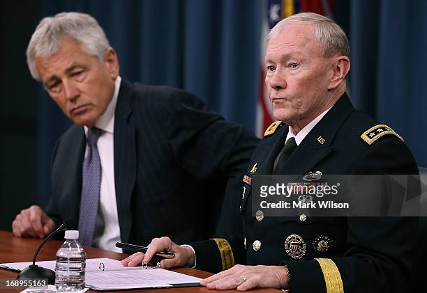 Secretary of Defense Chuck Hagel and Chairman of the Joint Chiefs of Staff Gen. Martin E. Dempsey listen to questions during a media briefing at the...