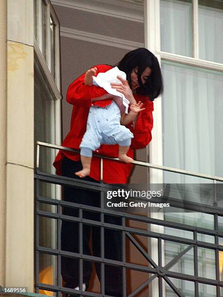 Singer Michael Jackson holds his eight-month-old son Prince Michael II over the balcony of the Adlon Hotel November 19, 2002 in Berlin, Germany....