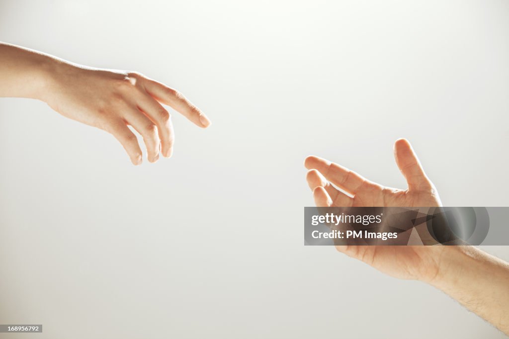 Hands reaching towards each other