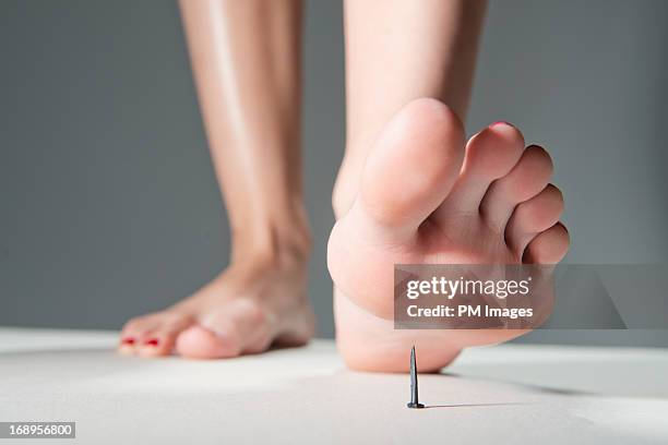 foot about to step on nail - barefoot soles female stock pictures, royalty-free photos & images