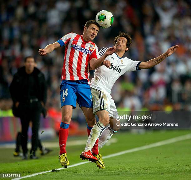 Captain Gabi Fernandez of of Atletico de Madrid competes for the ball with Fabio Coentrao of Real Madrid CF during the Copa del Rey Final match...