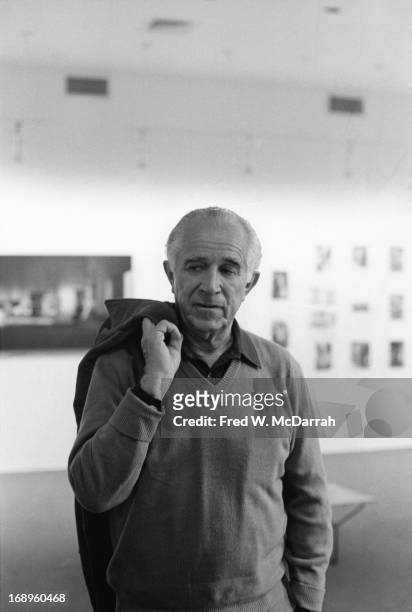 Portrait of American photographer David Douglas Duncan as he poses, coat over his shoulder, at an exhibition of his work at the Sidney Janis Gallery,...