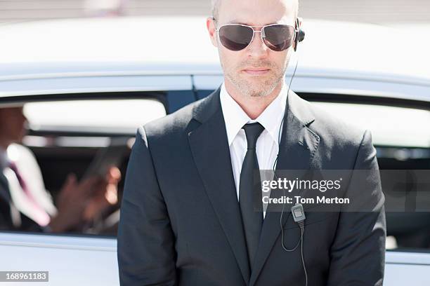 bodyguard wearing earpiece - bodyguard stock pictures, royalty-free photos & images