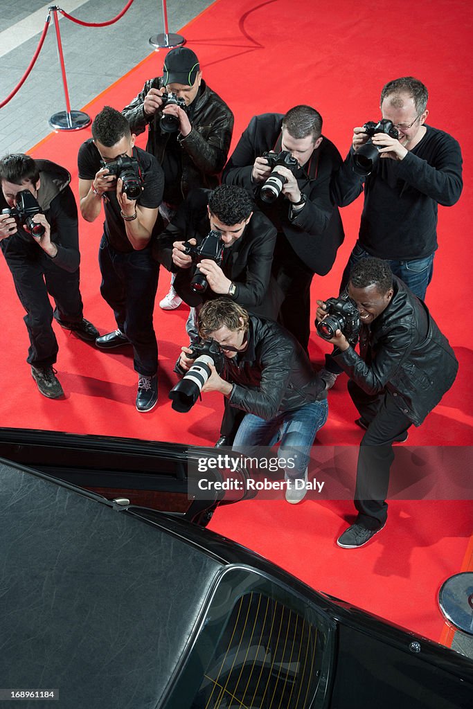Paparazzi taking photos of celebrity's car