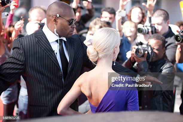 bodyguard protecting celebrity on red carpet - body guards stock pictures, royalty-free photos & images