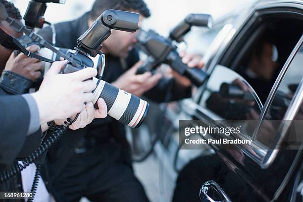 paparazzi retención de la lente de la cámara de ventana de coche - paparazzo fotografías e imágenes de stock
