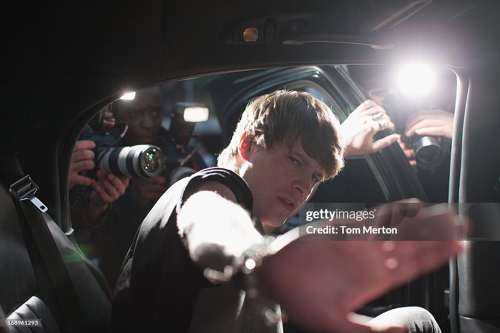 Celebrity blocking photo in backseat of limo