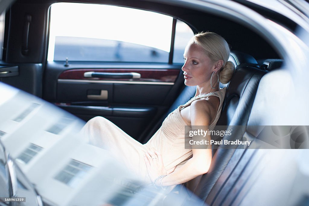 Woman sitting in backseat of limo