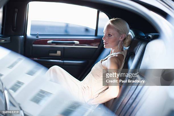 woman sitting in backseat of limo - limousine car stock pictures, royalty-free photos & images