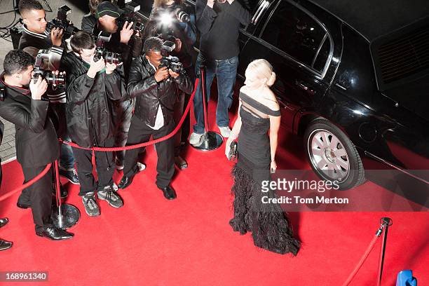 celebrity posing for paparazzi on red carpet - red carpet paparazzi stock pictures, royalty-free photos & images