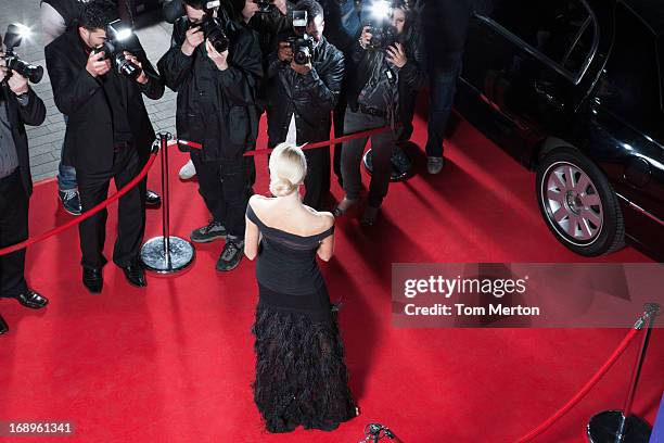 celebrity posing for paparazzi on red carpet - red carpet paparazzi stock pictures, royalty-free photos & images