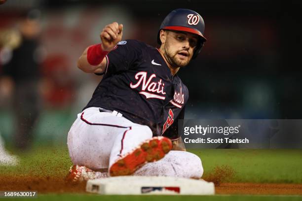 Lane Thomas of the Washington Nationals slides safely to reach third base against the Chicago White Sox during the first inning at Nationals Park on...