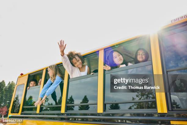 medium wide shot middle school girl waving out window of school bus - open day 13 stock pictures, royalty-free photos & images