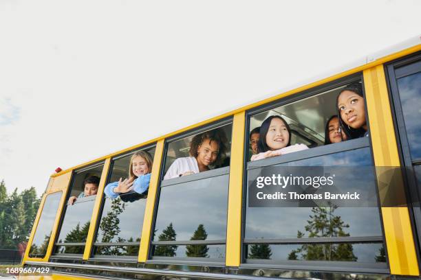 medium wide shot middle school kids looking out windows of school bus - open day 13 stock pictures, royalty-free photos & images