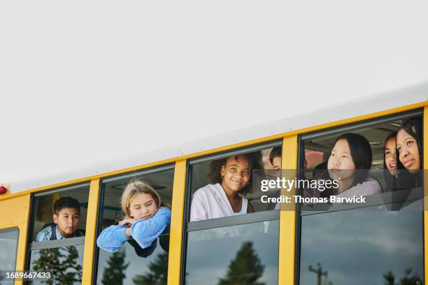 medium wide shot middle school kids looking out windows of school bus - open day 13 stock pictures, royalty-free photos & images