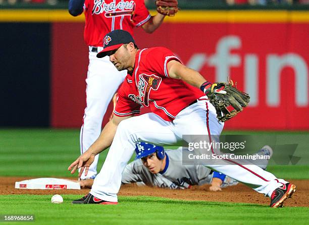 Dan Uggla of the Atlanta Braves is unable to field a ground ball as A. J. Ellis of the Los Angeles Dodgers advances to second base at Turner Field on...