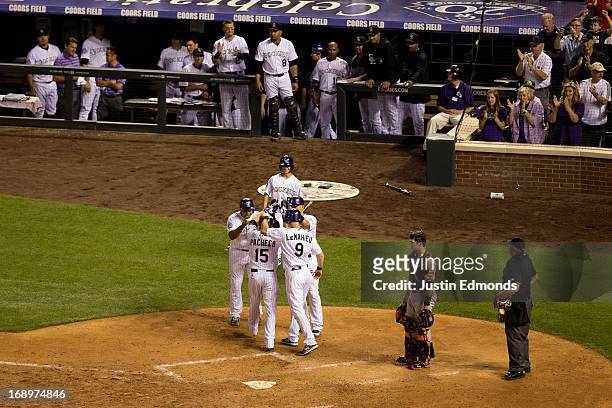 Jordan Pacheco of the Colorado Rockies is mobbed at home plate after hitting a go-ahead grand slam during the fifth inning, giving the Rockies a 9-5...