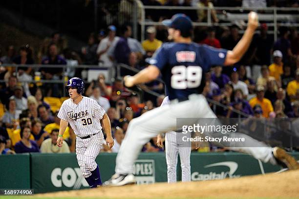 Alex Bregman of the LSU Tigers takes a lead as Sam Smith of the Ole Miss Rebels delivers a pitch during a game at Alex Box Stadium on May 17, 2013 in...