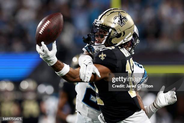 Chris Olave of the New Orleans Saints bobbles and catches a 42 yard pass against CJ Henderson of the Carolina Panthers during the third quarter in...