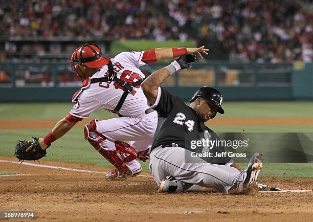 Dayan Viciedo of the Chicago White Sox slides safely past catcher Hank Conger of the Los Angeles Angels of Anaheim and scores a run in the seventh...