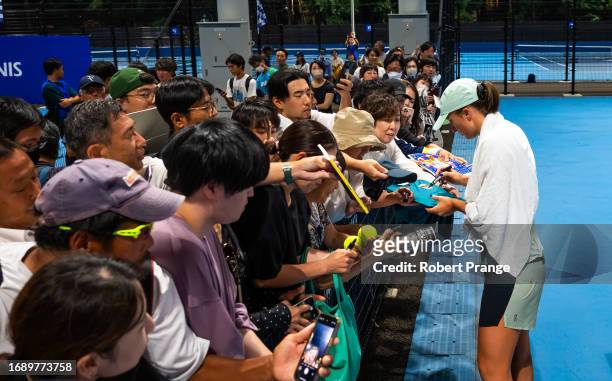 Iga Swiatek of Poland signs autographs after practice on Day 2 of the Toray Pan Pacific Open at Ariake Coliseum on September 26, 2023 in Tokyo, Japan